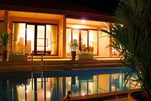 a house with a swimming pool in front of it at Peace Paradise Beach in Ko Lanta