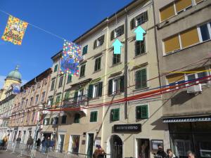 a kite flying over a building in a city at Via Corso in Rijeka