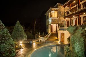 a house with a swimming pool at night at Casa Kirvá Hotel in Cobán