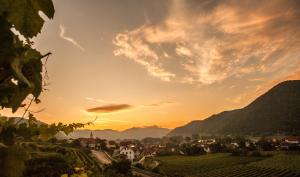 a view of a town at sunset with mountains at Hotel Garni Weinquadrat in Weissenkirchen in der Wachau