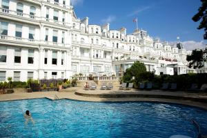 een persoon in een zwembad voor een gebouw bij The Grand Hotel in Eastbourne