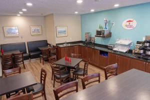 un restaurant avec des tables, des chaises et un comptoir dans l'établissement Super 8 by Wyndham Thunder Bay, à Thunder Bay