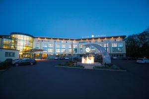 un grand bâtiment avec une horloge devant lui dans l'établissement Hotel Seehof Haltern am See, à Haltern