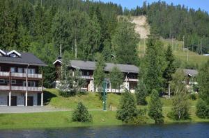 a large building on the side of a lake at Rinnetupa Apartment in Tahkovuori