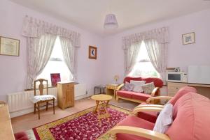 a living room with a pink couch and a table at Sunny Bank Guest House in Hythe
