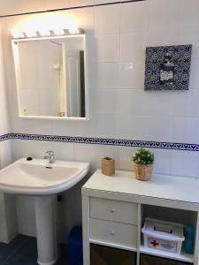 ein Badezimmer mit Waschbecken und Spiegel in der Unterkunft Apartamento Costa Ballena in Rota