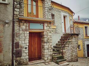 TorrecusoにあるLe Viole d'Oroの木製のドアと階段のある古い石造りの家