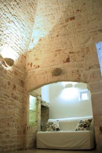 トゥーリにあるDimora Morelloのレンガの壁にソファが備わる部屋