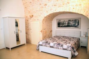 a bedroom with a bed and a brick wall at Dimora Morello in Turi