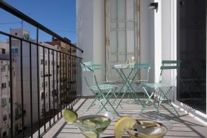 a balcony with chairs and a table on a building at SingularStays Parque Central in Valencia