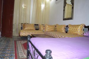 a living room with a bed and a couch at Chez L'habitant Boueden in Fez