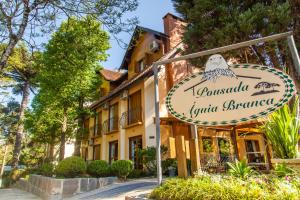 ein Schild für ein Restaurant vor einem Gebäude in der Unterkunft Pousada Águia Branca in Gramado