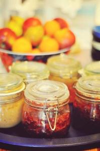 a tray of jars of jam with apples and oranges at Vagabonds Hostel in Belfast