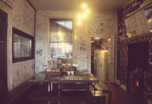 a kitchen with a table and a refrigerator at Vagabonds Hostel in Belfast