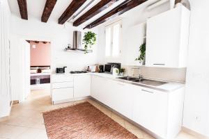 a kitchen with white cabinets and a sink at Cà Biennale: scoprire gli angoli nascosti! in Venice