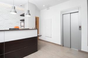 a kitchen with a black and white counter and a door at Hostal Granado in Madrid