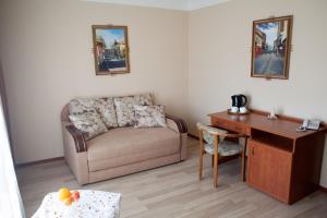a living room with a couch and a desk at Atlant Hotel in Uzhhorod
