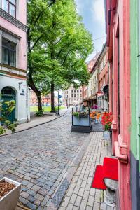 a cobblestone street in a city with a red bench at Dome square apartment, Old Town in Riga