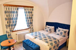 a bedroom with a bed and a table and a window at Pension Babenberger in Melk