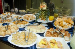 una tavola piena di diversi tipi di prodotti da forno e pane di Ímpar Suítes Expominas a Belo Horizonte