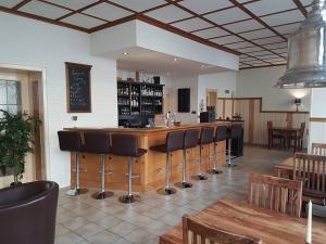 a bar with a row of bar stools in a restaurant at Herberg Die alte Schleuse in Manderscheid