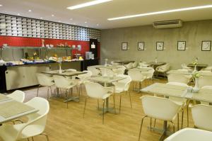 Um restaurante ou outro lugar para comer em Ímpar Suítes Expominas