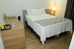 Cama ou camas em um quarto em Ímpar Suítes Expominas