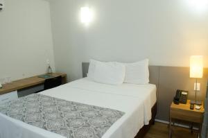 Cama ou camas em um quarto em Ímpar Suítes Expominas