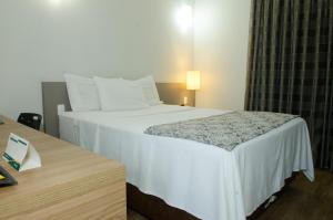 Cama ou camas em um quarto em Ímpar Suítes Expominas