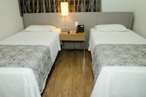 Cama ou camas em um quarto em Ímpar Suítes Expominas