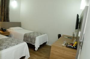 Cama ou camas em um quarto em Ímpar Suítes Expominas