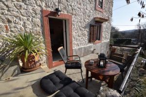 a patio with a couch and a table and a building at Cosy Getaway in Gostinjac