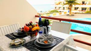 ein Tisch mit Tellern voller Essen und einer Schale Obst in der Unterkunft Luxury Tagara Beach in Puerto de Santiago