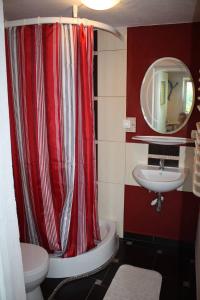 baño con cortina de ducha roja y lavamanos en Wimika, en Kowalowy