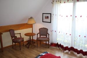 a living room with chairs and a table and a window at Wimika in Kowalowy +1 photo