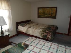a bedroom with a bed and a table with a lamp at Fishing Creek Lodge at Ricketts in Benton