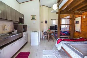 a kitchen with a sink and a table in a room at Green Mountain Pousada in Florianópolis