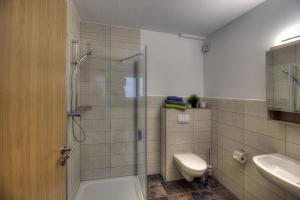 a bathroom with a shower and a toilet and a sink at Pader-Motel in Paderborn