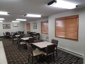 Americas Best Value Inn and Suites Bismarck في بسمارك: غرفة طعام فيها طاولات وكراسي