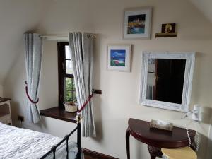 a bedroom with a bed and a mirror and a table at The Old Coach House in Pitlochry