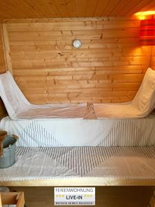a bed in a room with a wooden wall at LIVE-IN Wertheim am Main in Wertheim