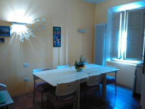uma sala de jantar com uma mesa branca e cadeiras em B&B Tamburini em Cotignola