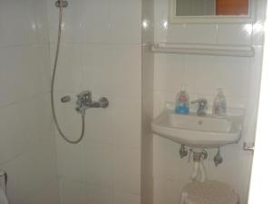 biała łazienka z umywalką i prysznicem w obiekcie Apartment city center w mieście Patras +16 zdjęć