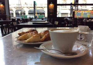 uma chávena de café e dois pratos de pastelaria numa mesa em Hotel Mar Del Plata em Termas de Rio Hondo