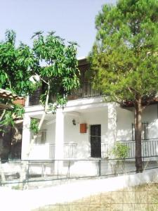 a white house with a tree in front of it at Thanasis Efh House in Stenón