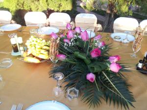 un tavolo con un centrotavola di rose rosa e frutta di Hotel Paradis a Slatina