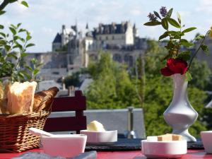 a table with a basket of bread and a vase with a rose at Le Point De Vue De Leonard in Amboise