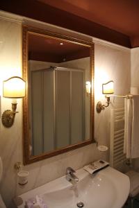 a bathroom with a sink, mirror, and bathtub at Il Piccolo Castello in Monteriggioni