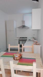 una cucina con tavolo e sedie in legno e una cucina con piano cottura di Casa Le Cementine a Verbania