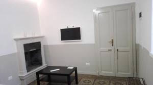 a living room with a fireplace and a tv on the wall at Casa Le Cementine in Verbania